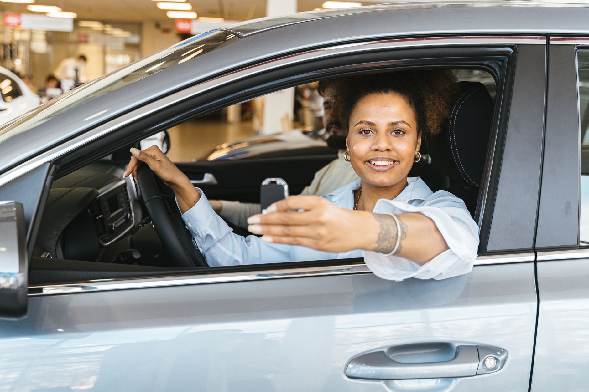 Mulher sorridente dirigindo um carro